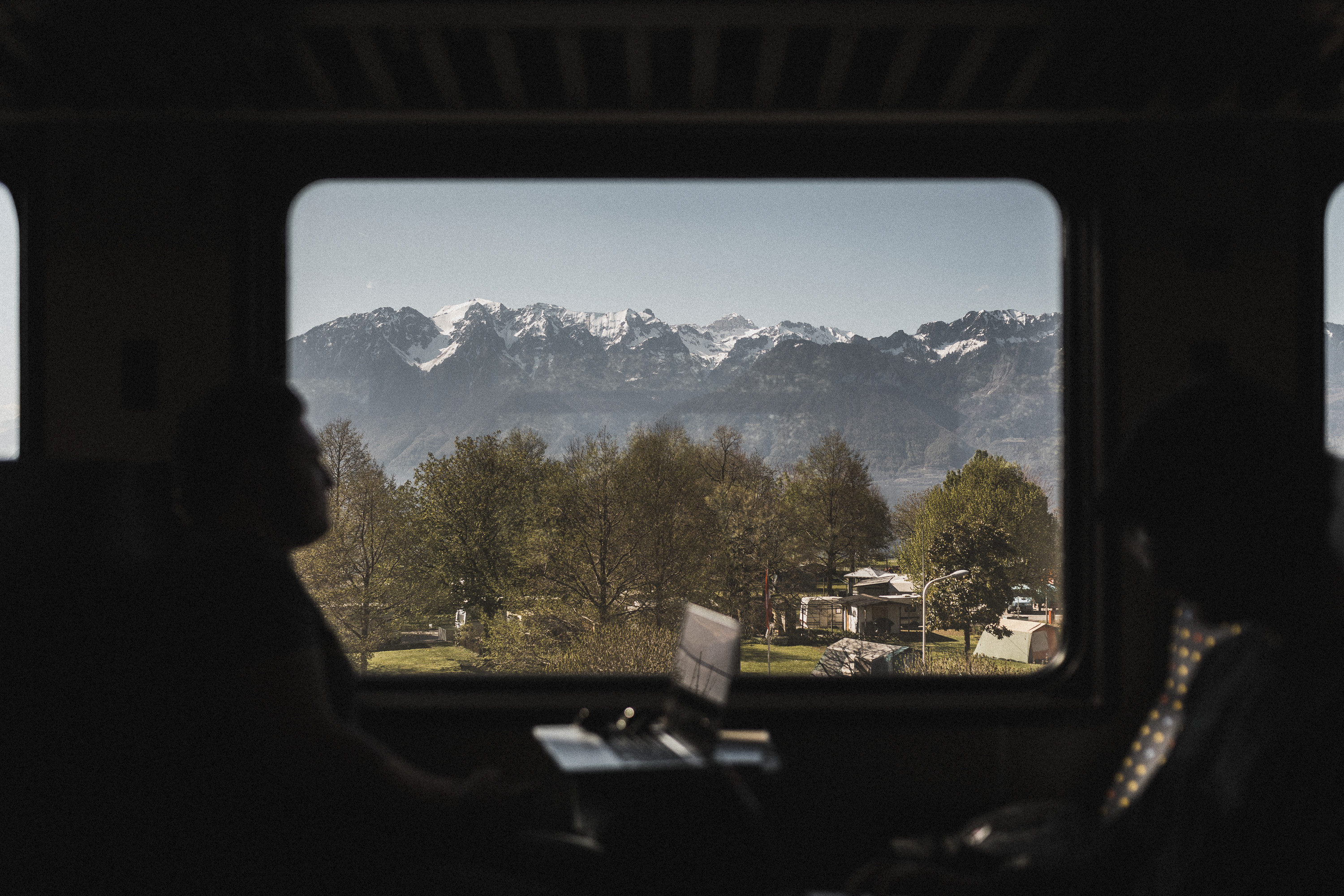 Aussicht aus dem Zug, Sicht auf Berge, Bäume und einen Campingplatz