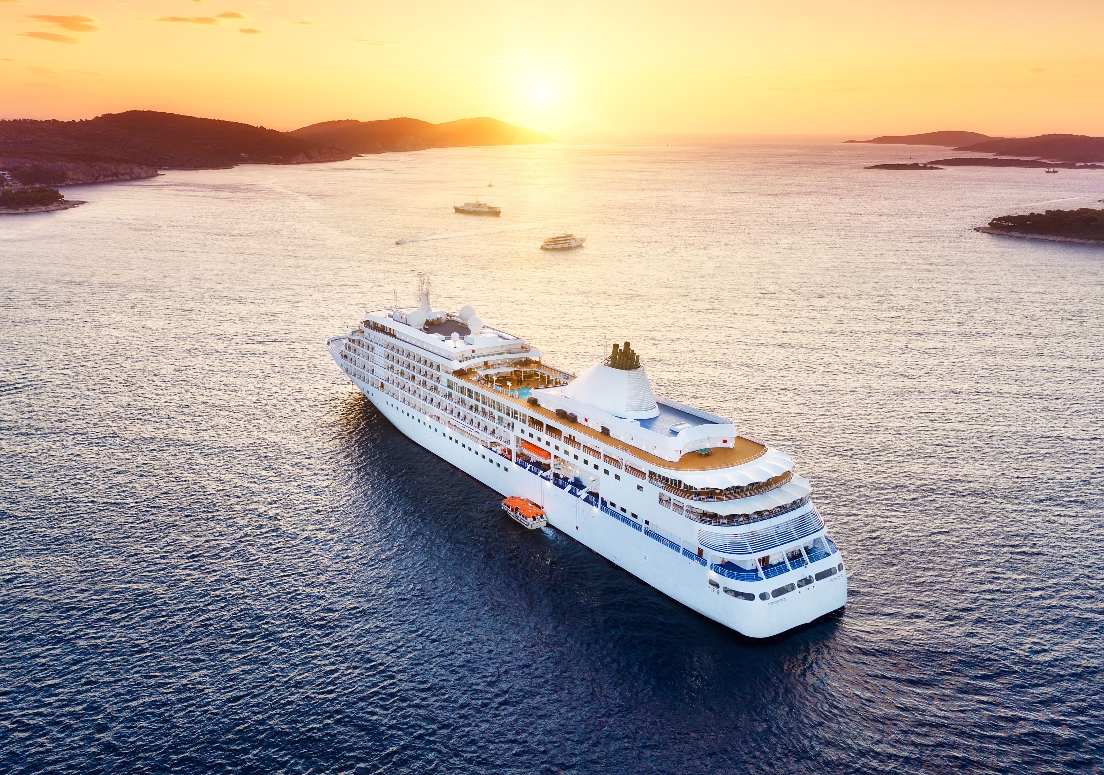 Weisses Kreuzfahrtschiff auf dem Meer vor Sonnenuntergang