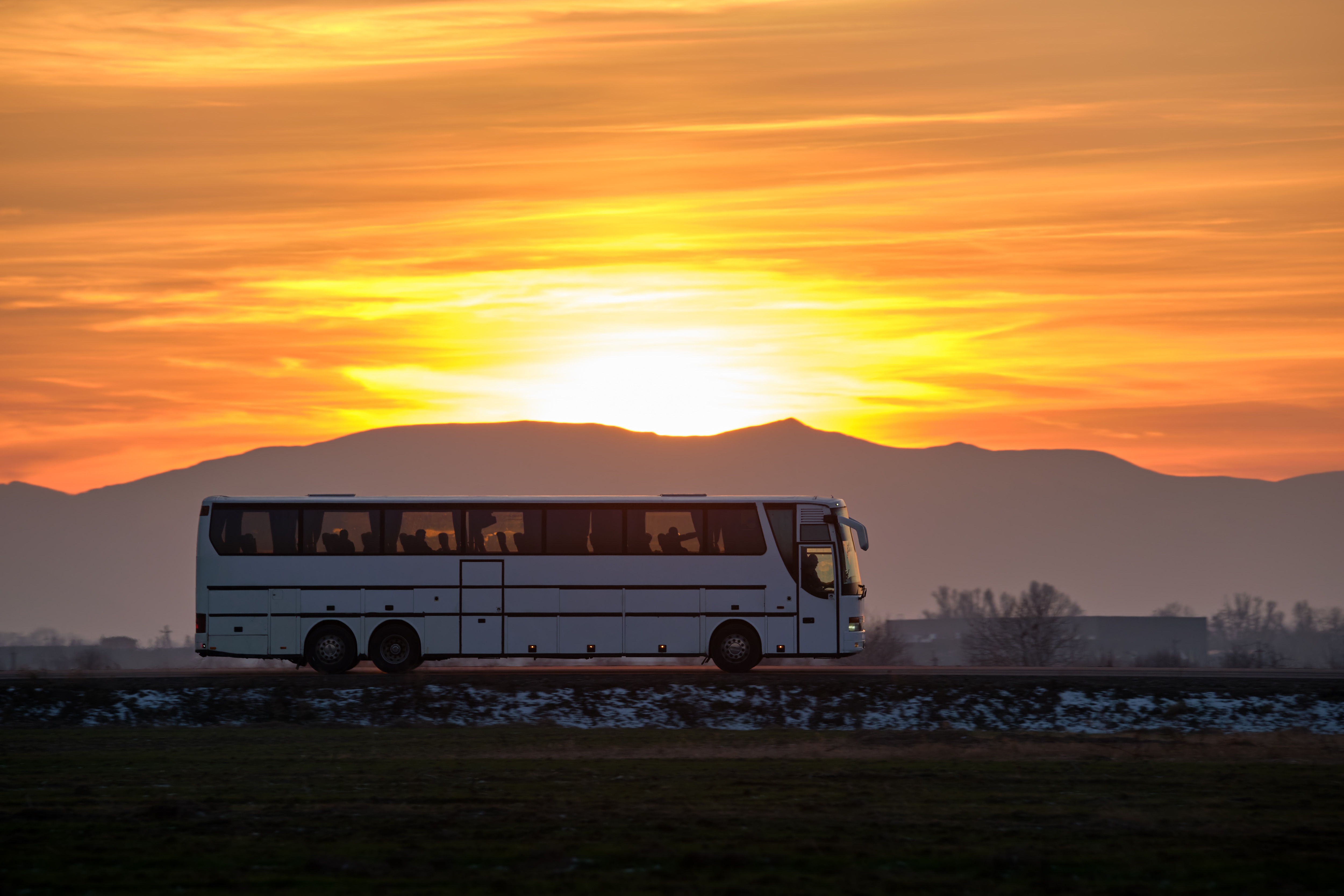 Car auf einer geraden Strasse mit dem Sonnenuntergang im Hintergrund